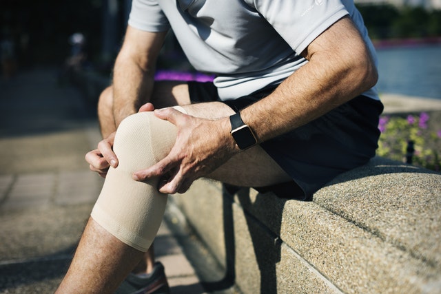 hombre vendando su rodilla